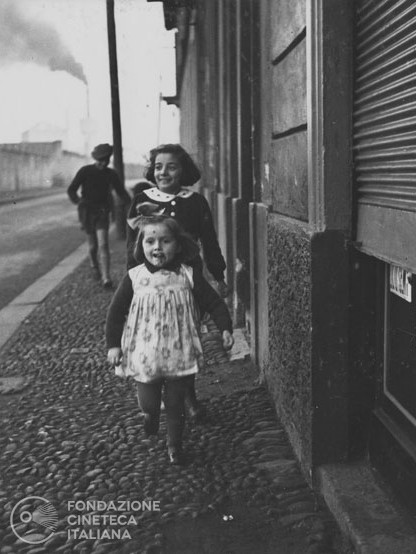 Bambini che giocano lungo una strada alla periferia di Milano