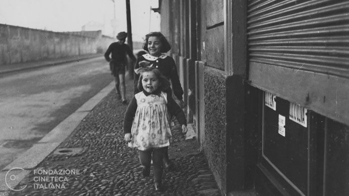 Bambini che giocano lungo una strada alla periferia di Milano